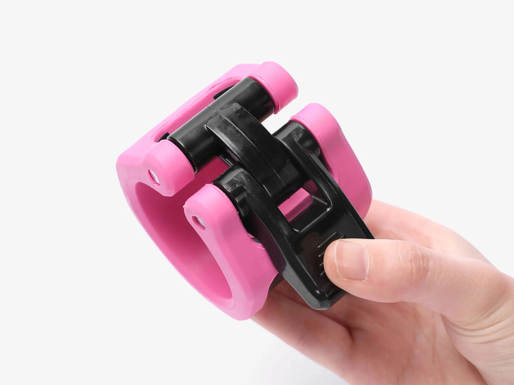 Side Angle Of Pink Barbell Collar Held In Hand For Size Reference
