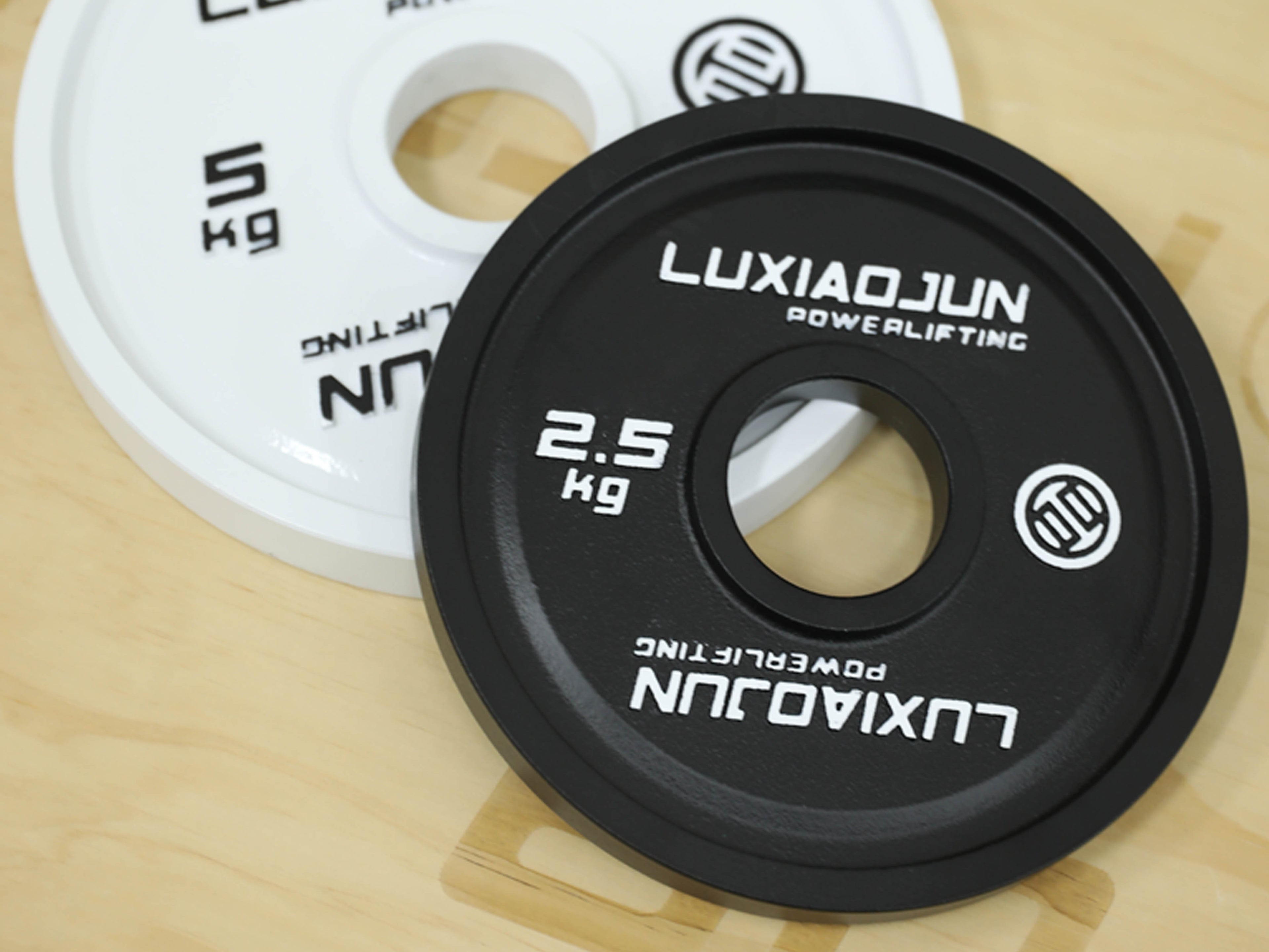 Close-up of LUXIAOJUN Powerlifting Competition Plates in white and black