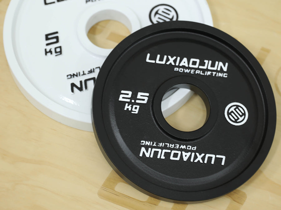 Close-up of the machined center hole on the white 5 kg and black 2.5 kg LUXIAOJUN powerlifting plates