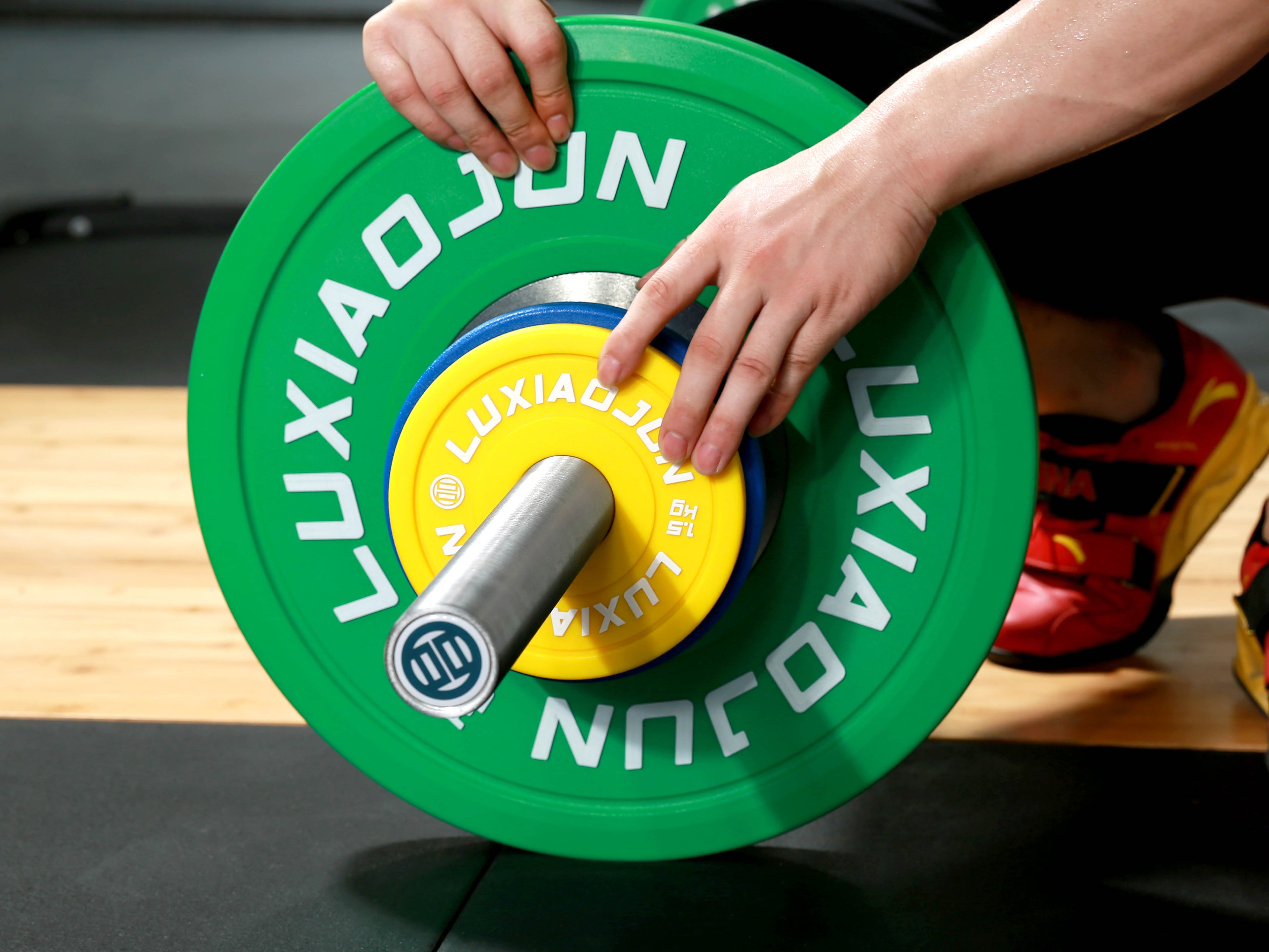 Detail shot of LUXIAOJUN Urethane Change Plates 25KG Set being loaded by hand