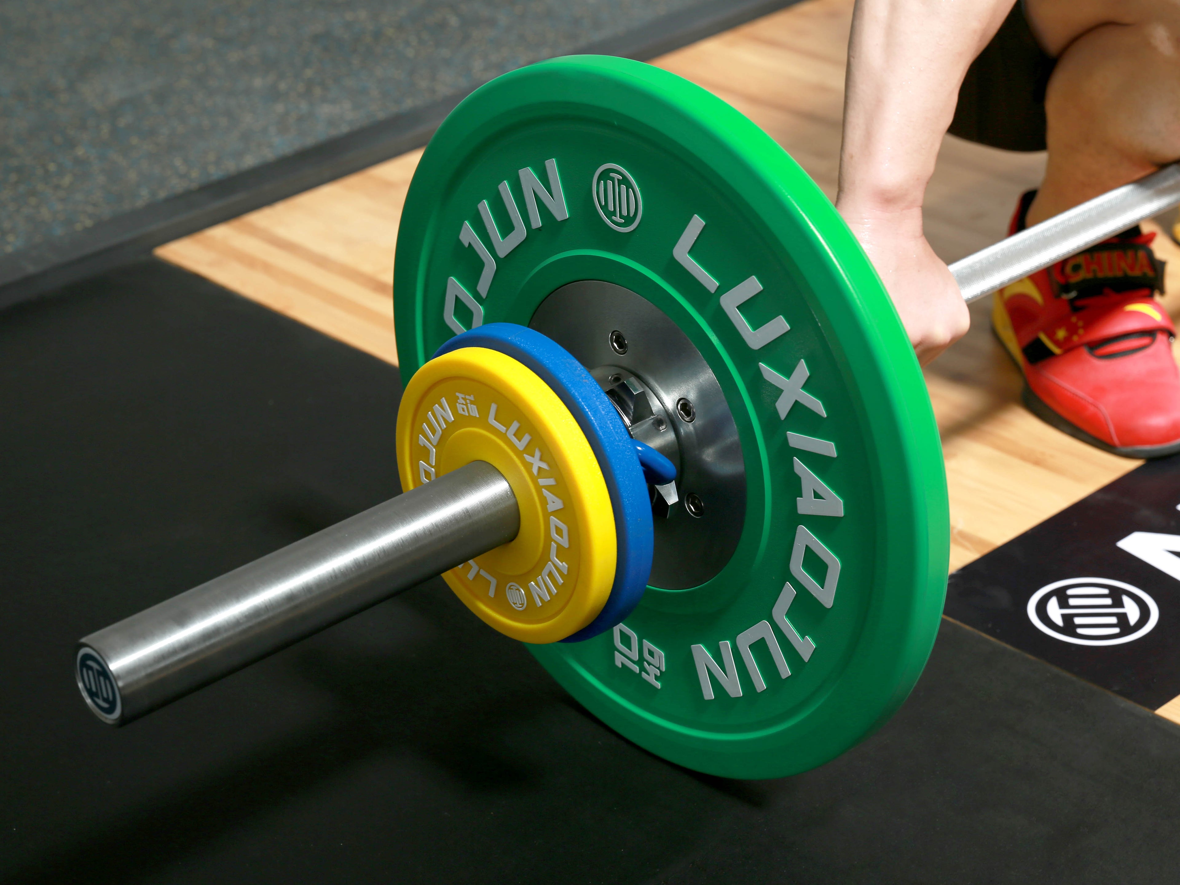 Lifter using LUXIAOJUN Urethane Change Plates 25KG Set on a loaded barbell